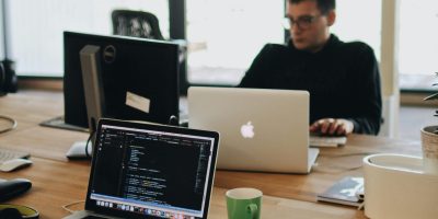 pexels-photo-2102416-2102416 A web developer working on code in a modern office setting with multiple devices.